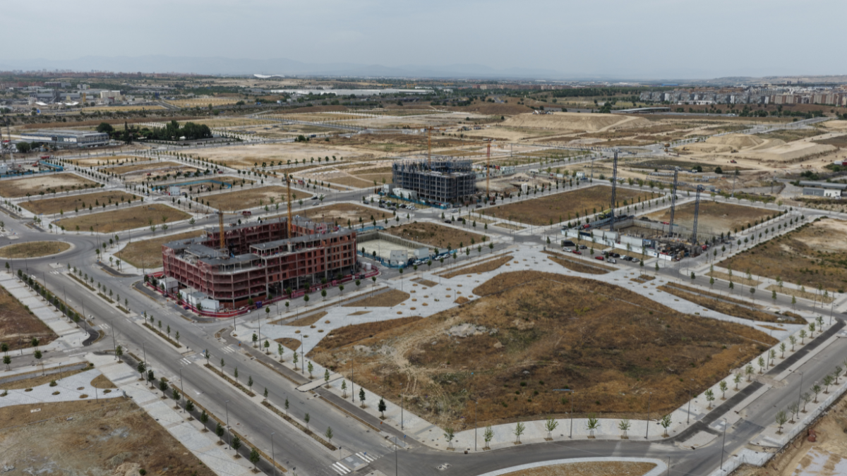 Vista aérea de Los Ahijones con calles urbanizadas, parcelas en desarrollo y edificios en construcción durante la creación del nuevo barrio.