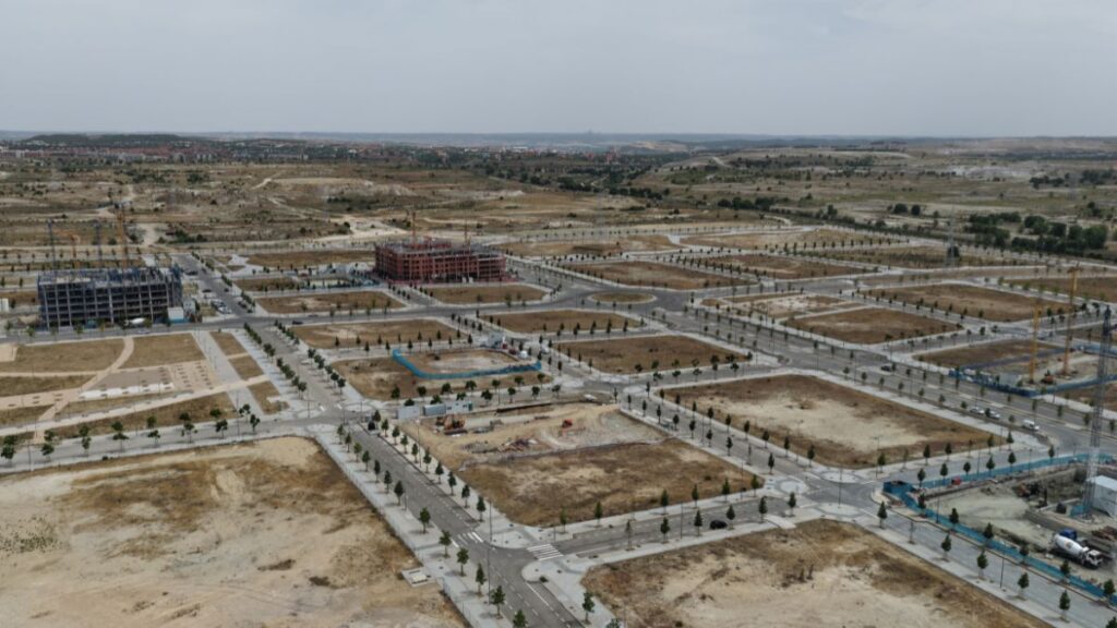 Vista aérea de Los Ahijones con viales urbanizados, parcelas en desarrollo y edificios en construcción en el sureste de Madrid.