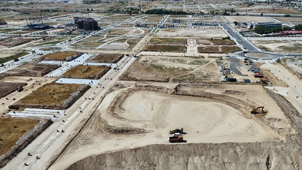 Vista aérea de Los Ahijones con trabajos de movimiento de tierras, calles urbanizadas y edificios residenciales en construcción.